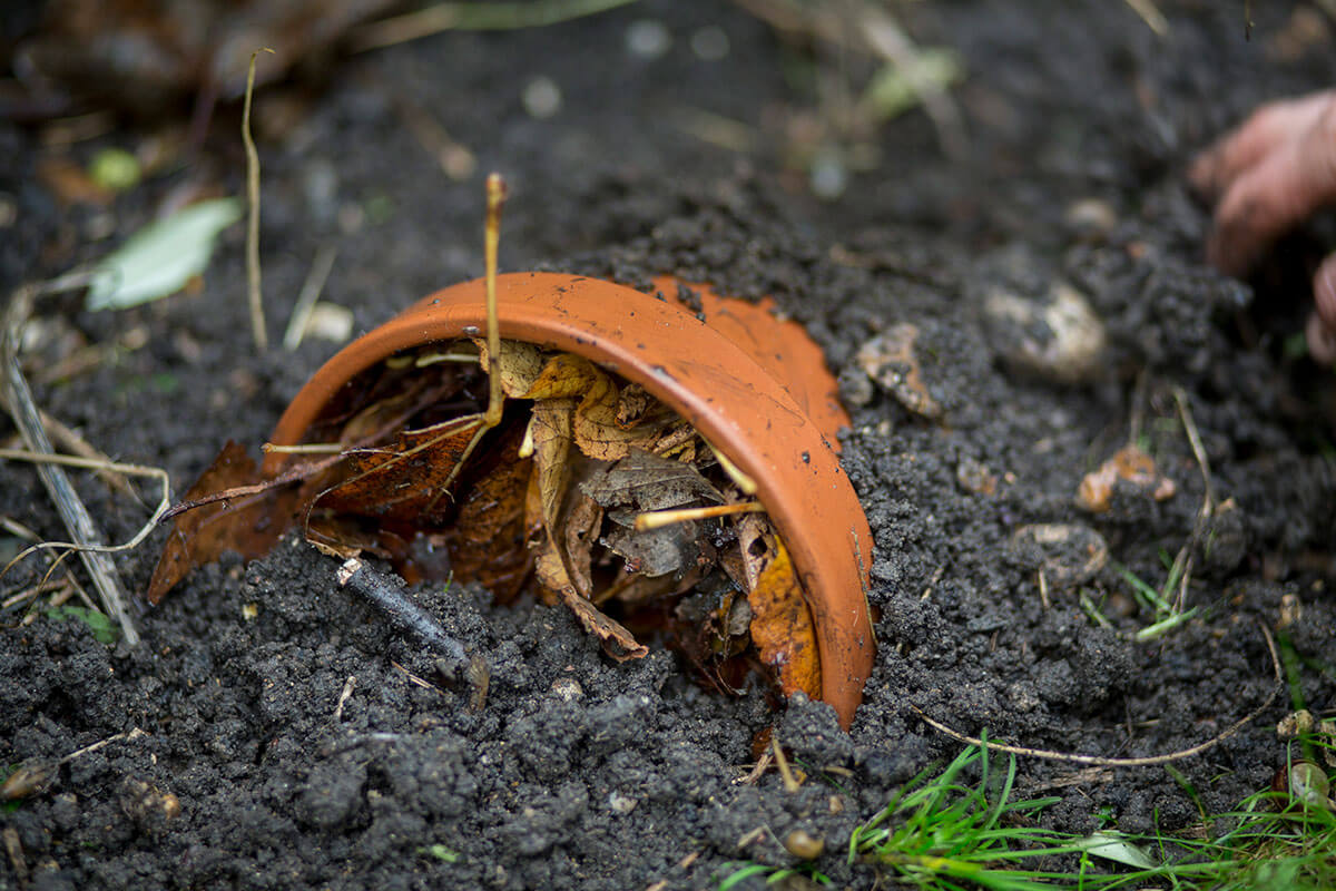 A partially submerged terracotta plant pot on its side